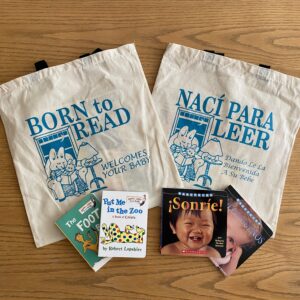 4 children books on top of tote bags from Born to Read organization